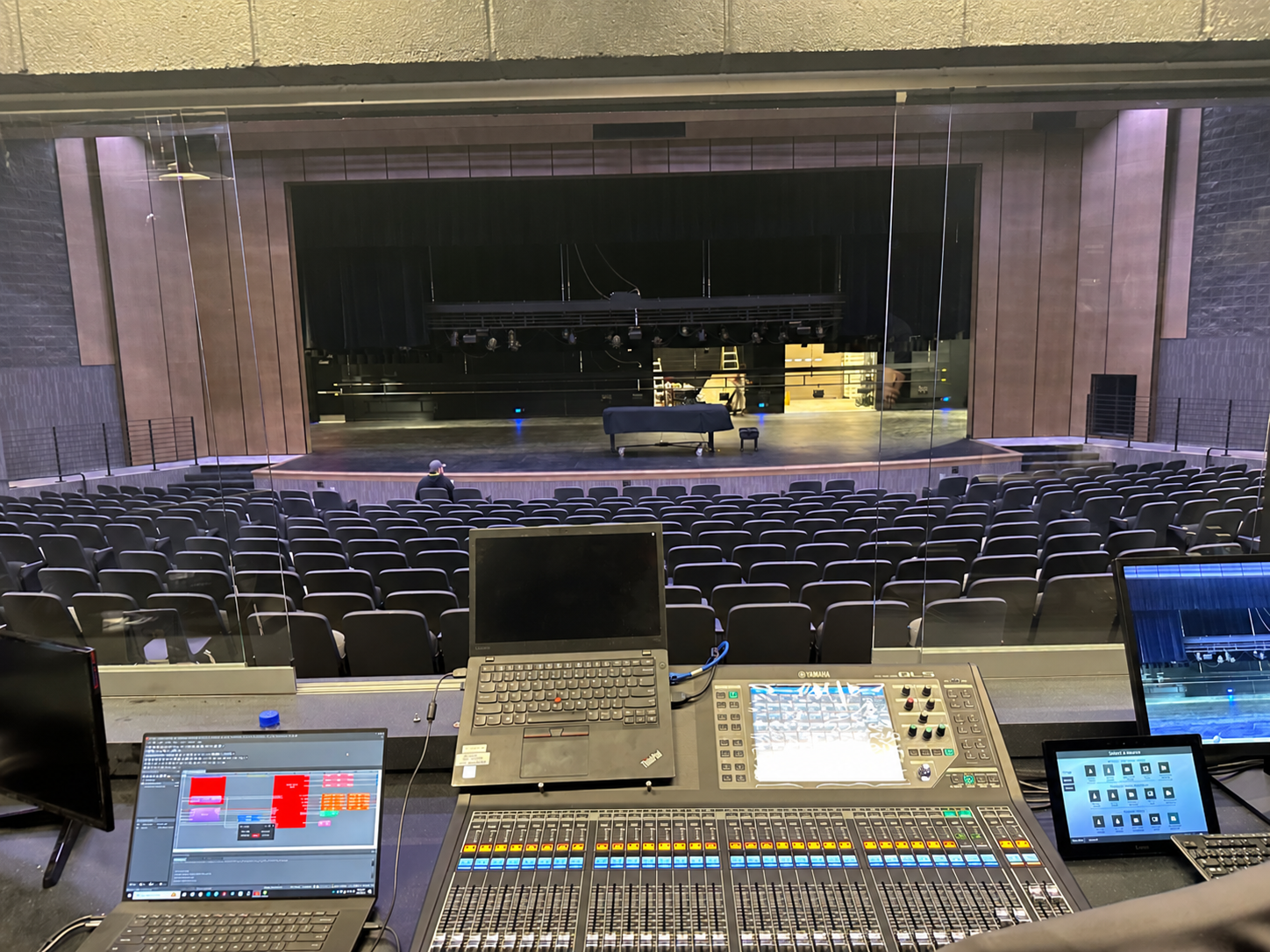 Auditorium viewed from a production position with a Yamaha mixing console and touch panels